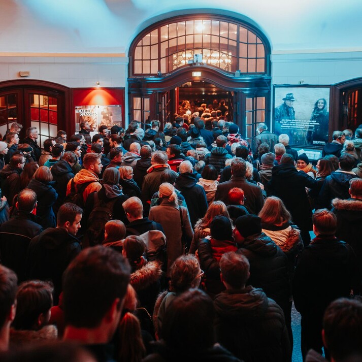 Menschenmenge wartet im Foyer, um an einem beliebten Filmevent teilzunehmen.