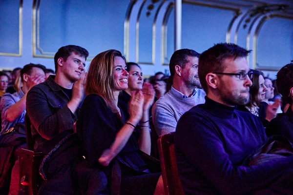 Audience applauding during an event in a stylish hall