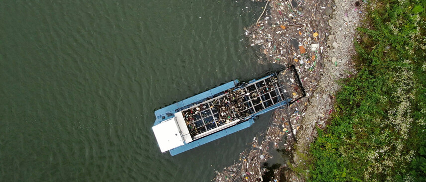 Ein Cleanup Boot reinigt einen mit M&uuml;ll beladenen Strand
